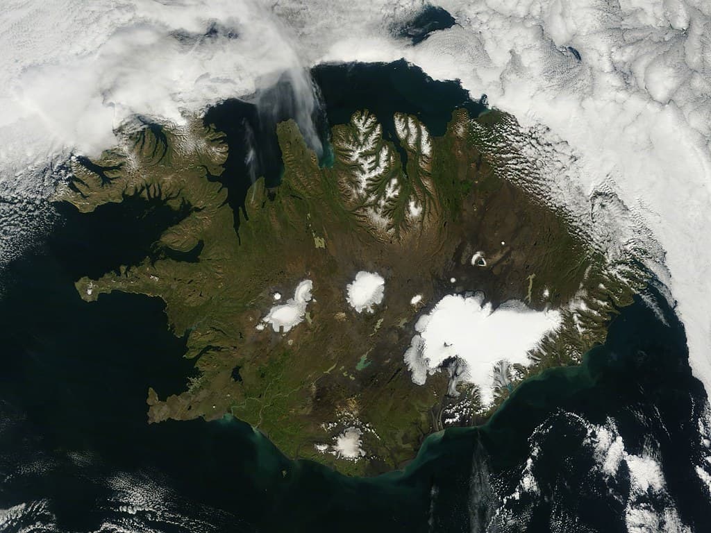Braided glacial rivers crossing black sand, seen from the air