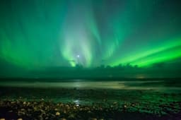 Green northern lights over a dark Icelandic sky