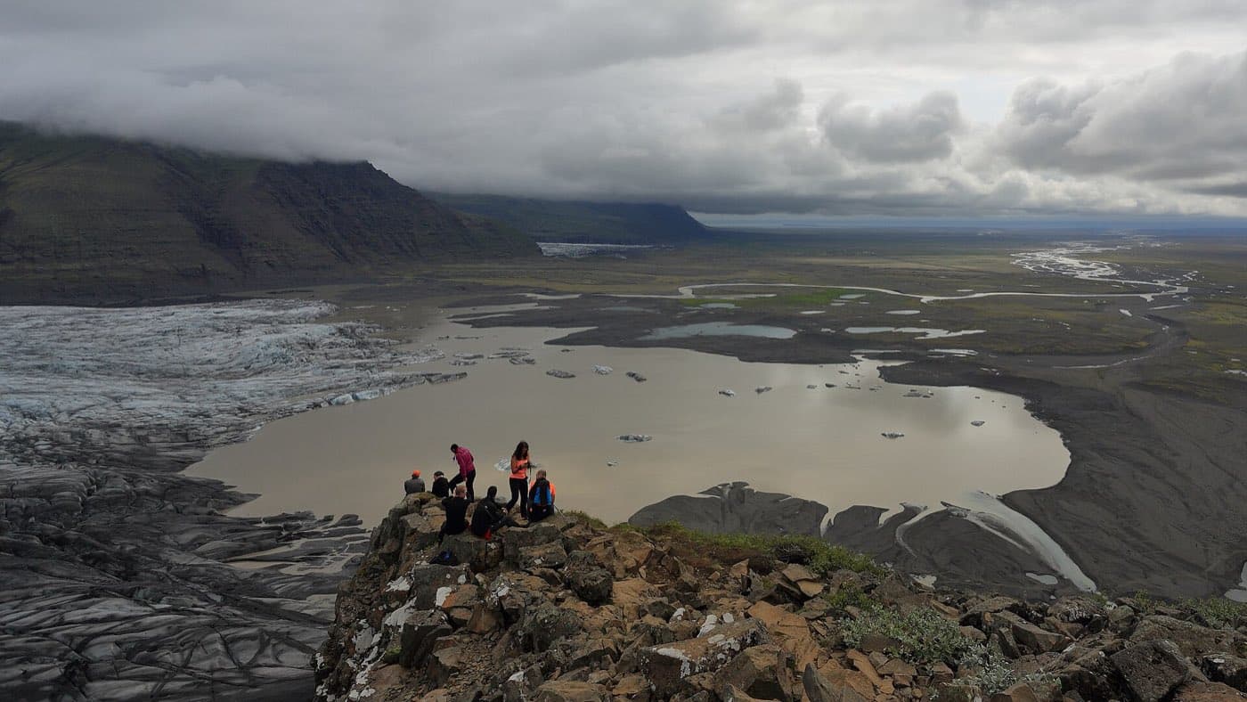 Hikers roped together in crampons crossing a glacier tongue