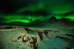Northern lights over Mount Kirkjufell and Kirkjufellsfoss waterfall