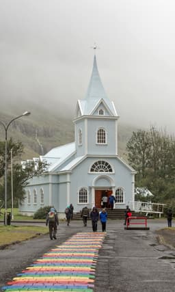 The blue church and rainbow street at Seydisfjordur in east Iceland